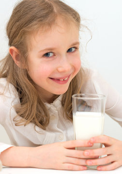 Cute little girl with glass of milk.