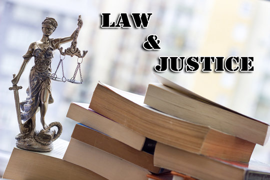 Justice statue with sword and scale and books. Law concept