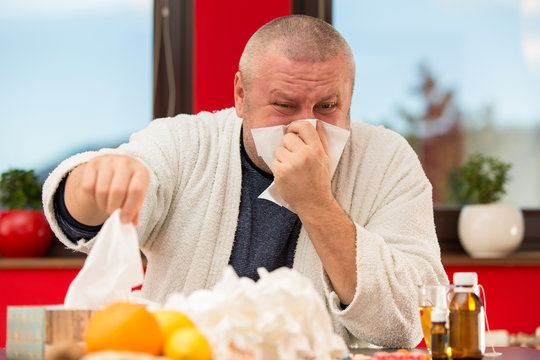 Sick Man Suffering Cold And Winter Flu Virus Drinking Tea