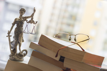 Justice statue with sword and scale and books. Law concept