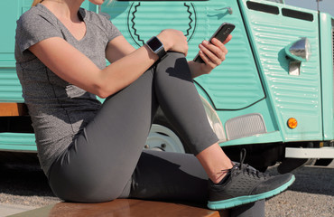 Woman looking at mobile phone after workout. Running, jogging, sport, active lifestyle concept. Female athlete resting and relaxing after workout.
