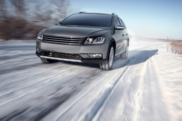 Fototapeta premium Gray modern car drive speed on road at winter daytime