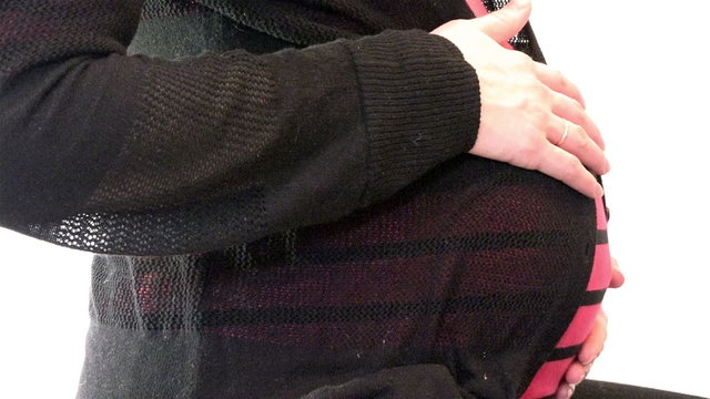 Woman on the ninth month of pregnancy stroking belly