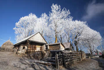 Winter rural landscape with cottage on the hill