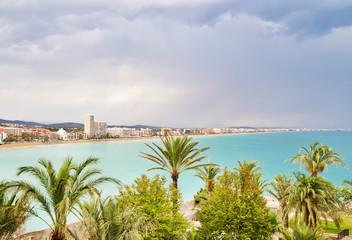 View over the palm trees and coastline of Peniscola, Spain