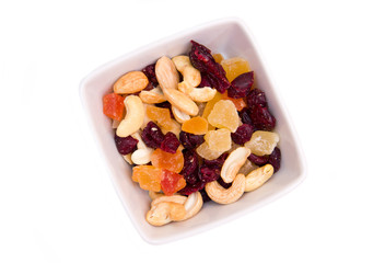 Dried fruits on square bowl on a white background seen from above