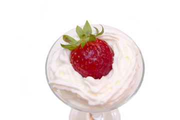 Glass with strawberry and cream on a white background seen up close
