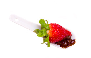 Teaspoon with strawberry and chocolate on a white background seen from above