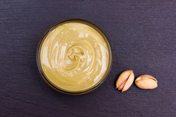 Pistachio cream in bowl on slate top view from above