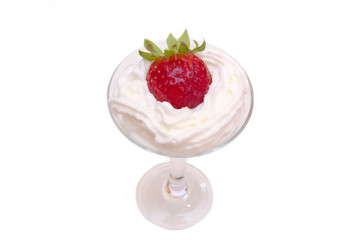 Glass with strawberry and cream on a white background seen from above