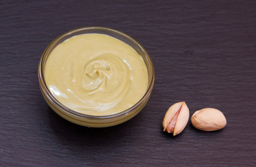 Pistachio cream in bowl on slate top