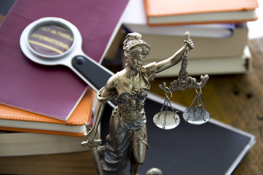 Family law. Justice statue with sword and scale and marriage certificate