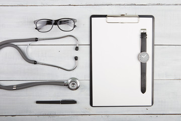 Workplace of doctor - stethoscope, medicine clipboard, glasses a