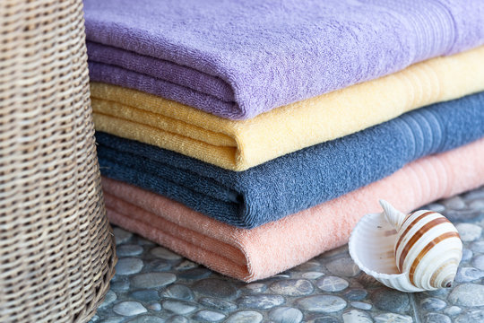 Colorful fresh towels  in a cosy interior  close up. Blue theme and a seashell 