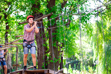 Naklejka na ściany i meble adventure climbing high wire park - people on course in mountain