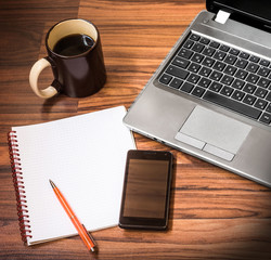 Workplace with laptop, smartphone, copy-book, cup of coffee and headphones 