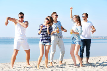 Obraz premium Young people with beer on the riverside