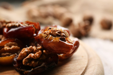 Walnut, date fruit on wooden table, close-up