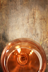 Glass of wine on wooden table. Top view