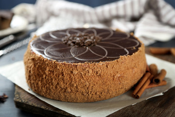 Tasty chocolate cake on color wooden background