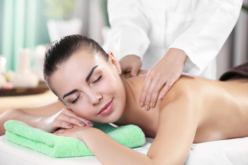 Fototapeta na wymiar Beautiful young woman relaxing with hand massage at beauty spa, closeup