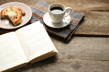 Open book and snack on wooden table background