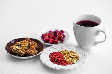 Cup of tea with aromatic dry tea on wooden background