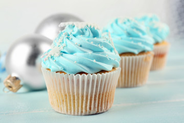 Few tasty blue cupcakes with decorations on light background