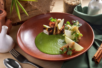 octopus barbeque served with slice of apple, broccoli and green