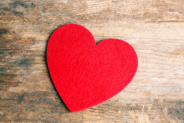 Fototapeta na wymiar Red felt heart on wooden background