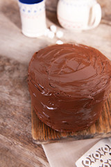 Chocolate cake with blade on a wooden boards background