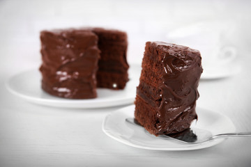 Chocolate cake on plates with a cut piece on light background
