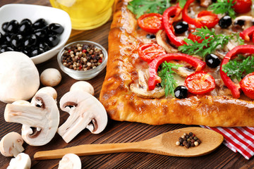 Freshly homemade pizza on wooden table closeup