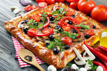 Freshly homemade pizza on wooden table closeup