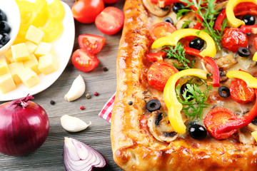 Freshly homemade pizza on wooden table closeup
