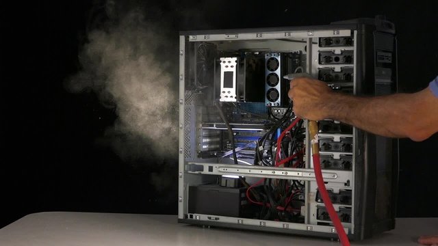 Computer maintenance with air gun blower. Dust blowing from computer case. Computer dust removal is an important factor to keep the peak performance.