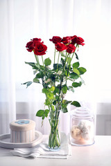 Bouquet of fresh red roses on windowsill background