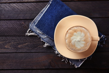 Milk coffee in cup on black wooden table