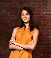 Fototapeta na wymiar Beautiful young girl posing on brick background