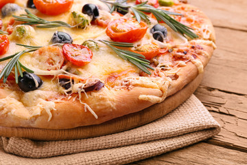 Delicious fresh pizza on wooden table closeup