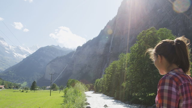 Switzerland nature Swiss Alps landscape with river Weisse L&uuml;tschine. Woman hiker hiking in alpine Lauterbrunnen valley. Jungfrau, Eiger, Monch mountains in background in Bernese Oberland, Schweiz.