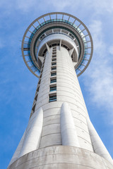 Auckland sky tower from below with blue sky background.