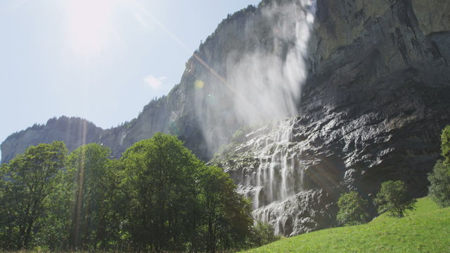 Woman hiking in Switzerland alps by waterfall Staubbach falls. Woman hiker walking in Swiss alpine nature landscape in Lauterbrunnen valley in Bernese Oberland, Schweiz, Europe. RED EPIC SLOW MOTION.