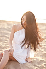 Fototapeta na wymiar Beautiful tender woman posing on the sunset beach