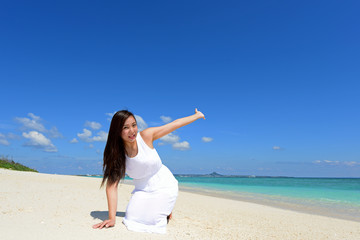 Fototapeta na wymiar 沖縄の美しいビーチでくつろぐ女性