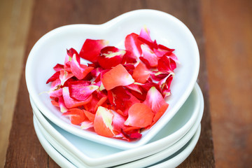 red rose and ceramic heart shape on old wooden