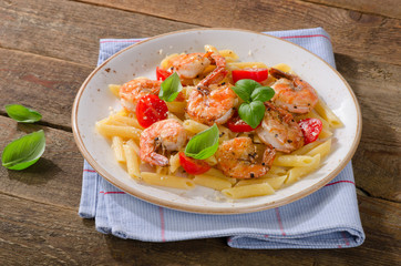 Penne pasta with shrimp, tomatoes and herbs.