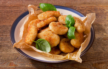 Crispy chicken nuggets on a wooden table.