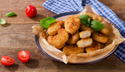 Crispy chicken nuggets on a rustic wooden background.