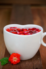 red rose and ceramic heart shape on old wooden
